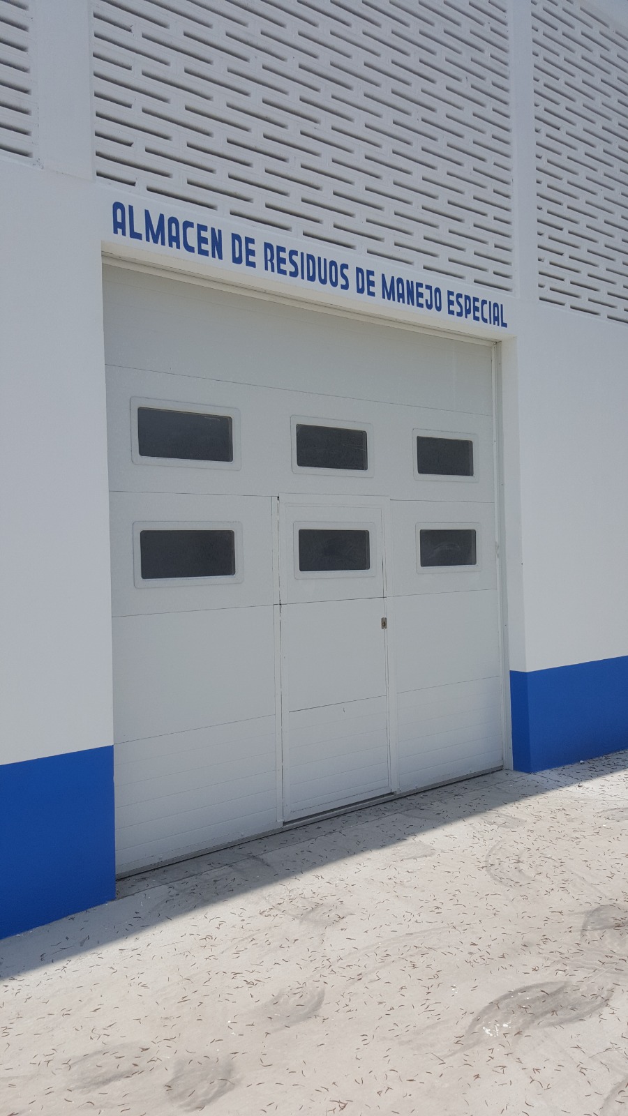 Puerta seccional con ventanas en almacén de residuos de manejo especial