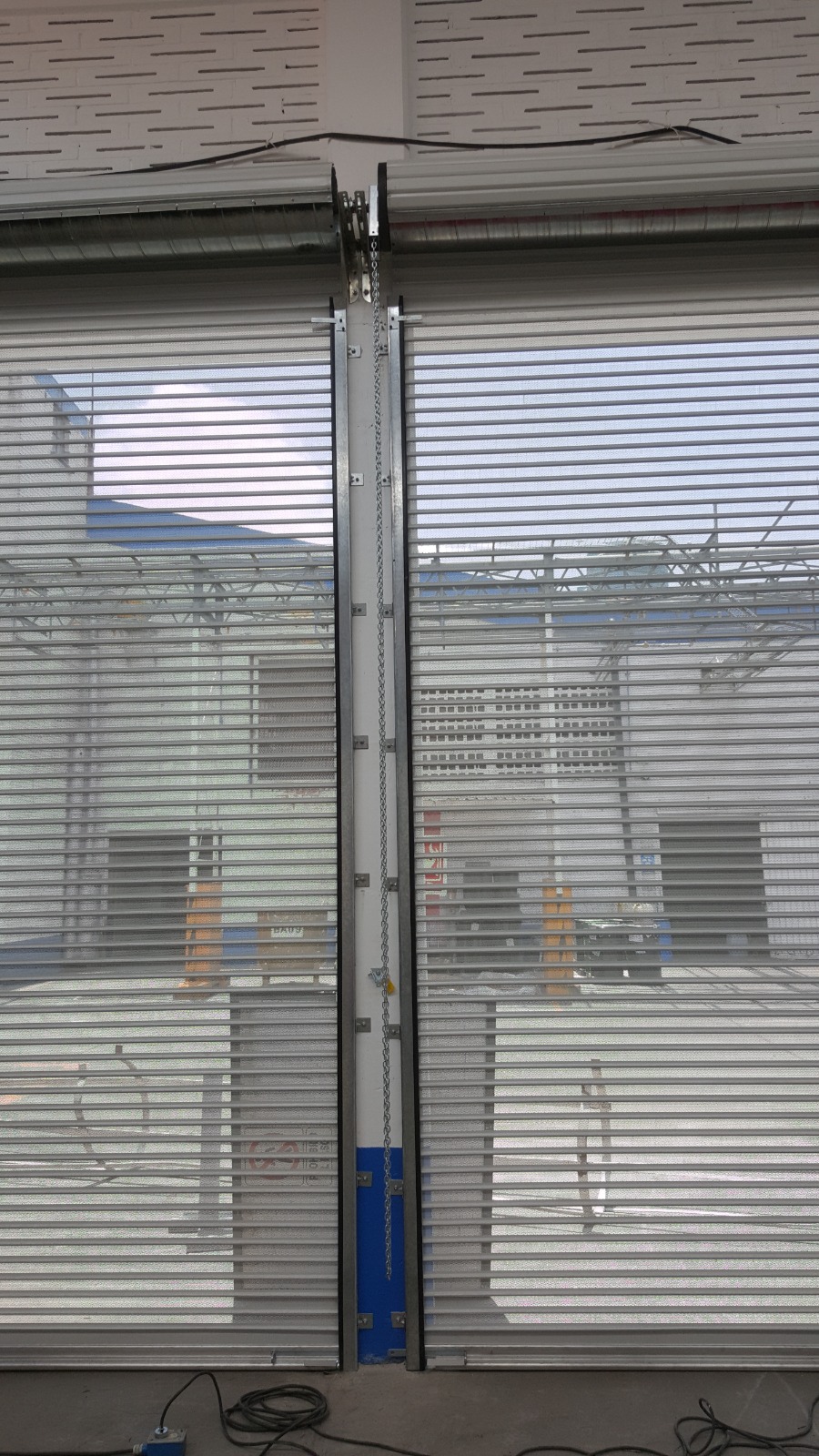 Cortinas metálicas microperforadas con guías y operador de cadena
